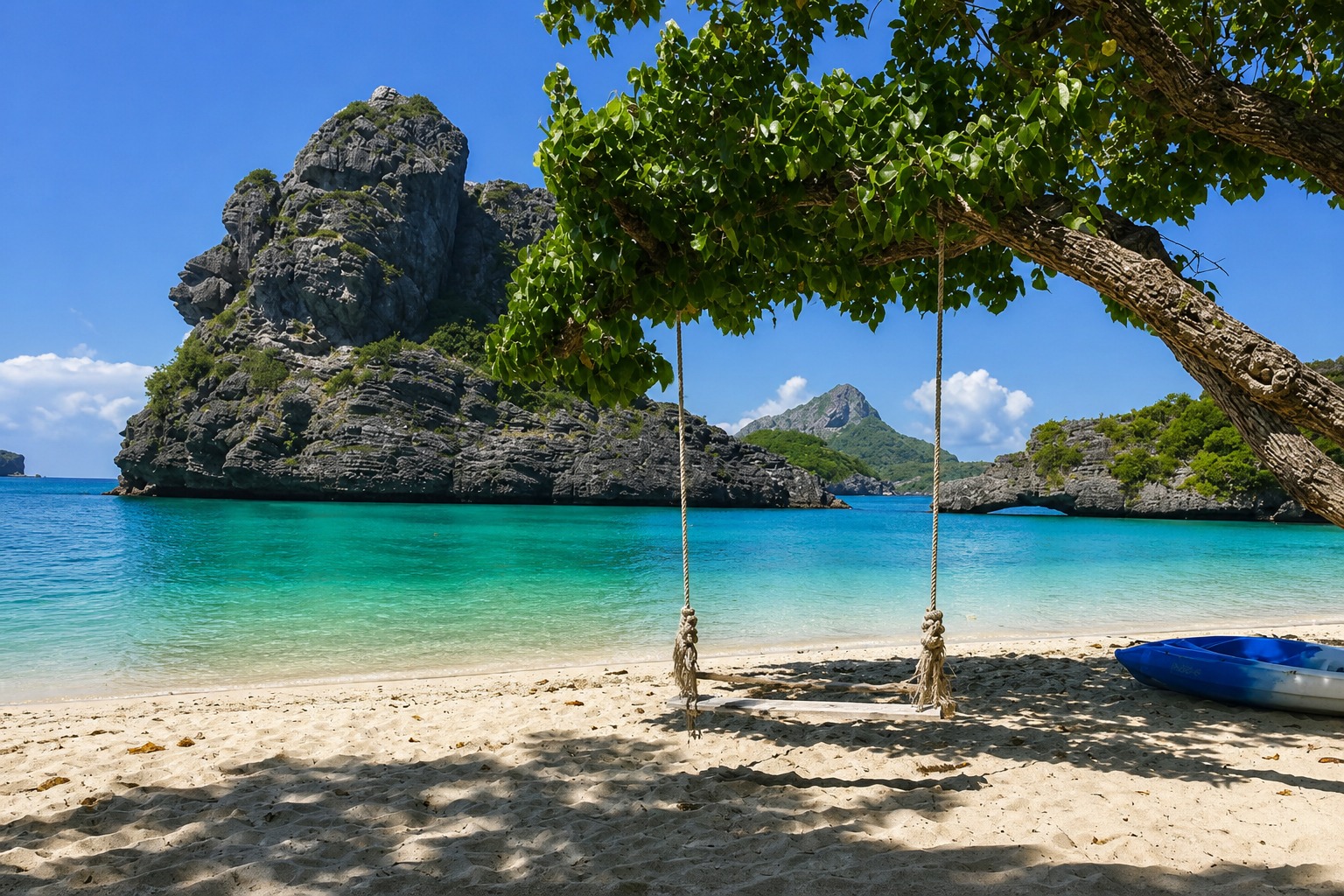 Beach swing under a shade tree with limestone islands behind, Ang Thong Marine Park