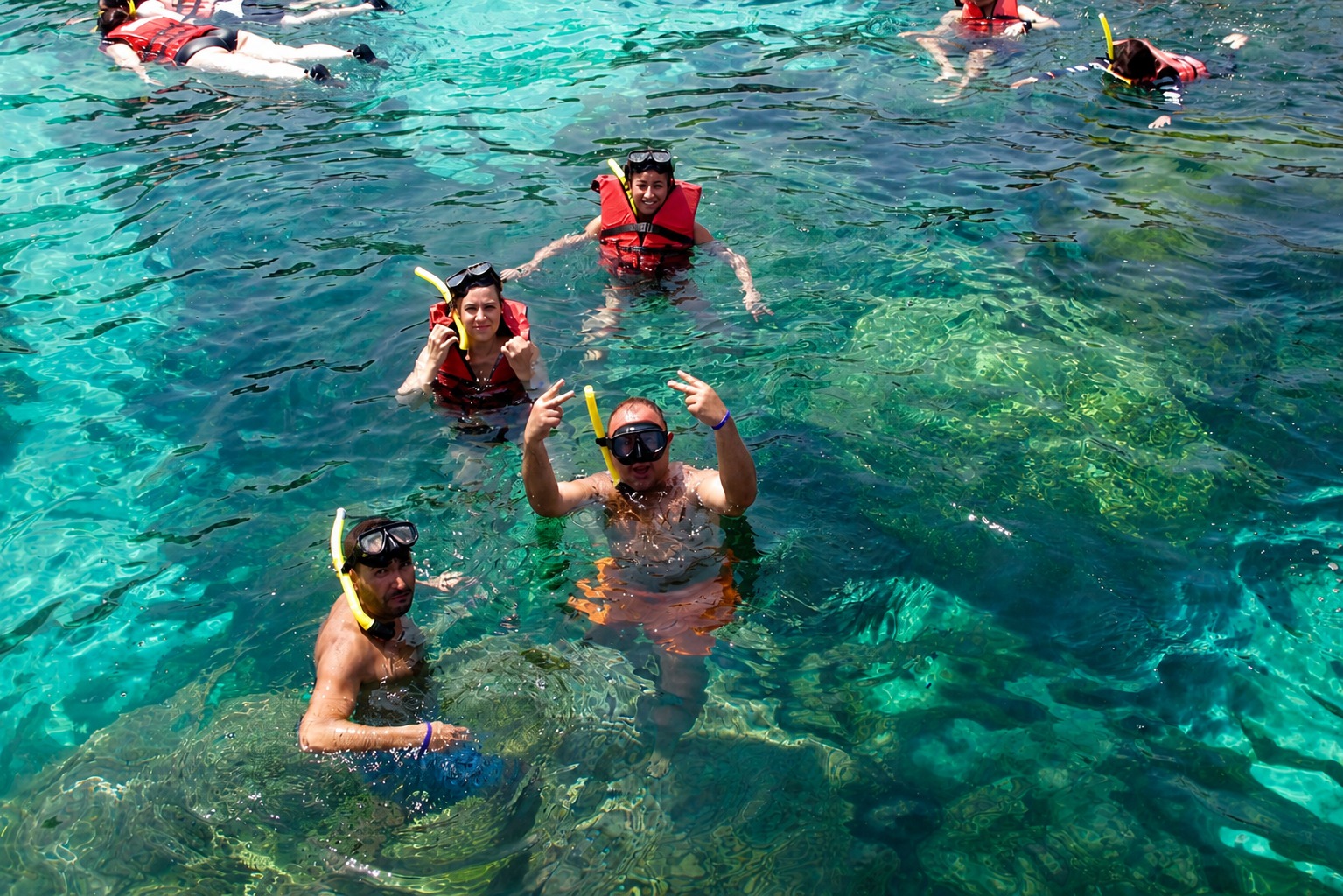 Group snorkelling in clear tropical water in life jackets, Ang Thong Marine Park